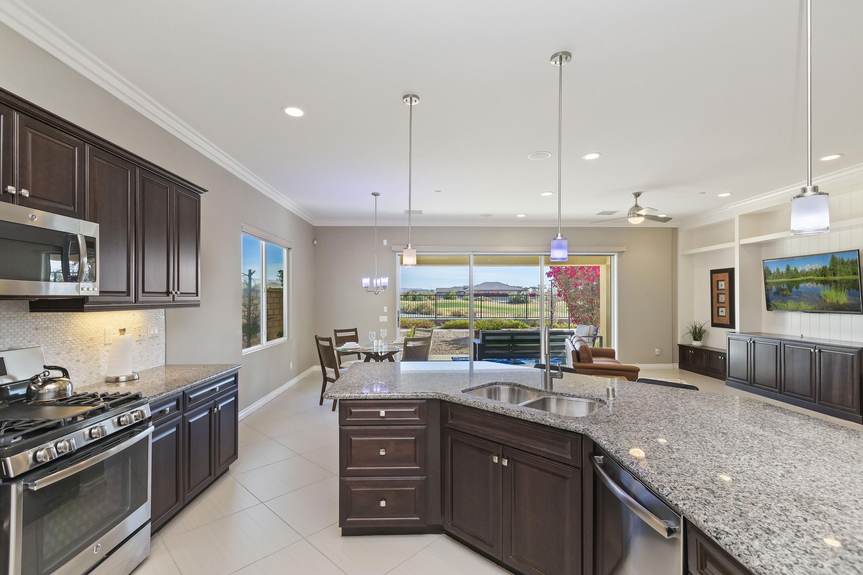 43020 Ascona Lane Indio, CA 92203 - Photo 9 of 33 a kitchen with stainless steel appliances granite countertop a sink a stove and a wooden floors