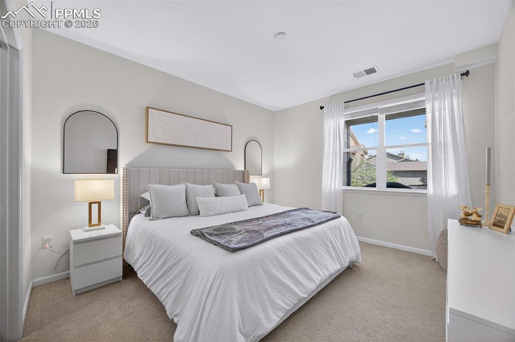 4658 Copeland Circle, Unit 103 Highlands Ranch, CO 80126 - Photo 22 of 37 a bedroom with a bed and a painting on the wall
