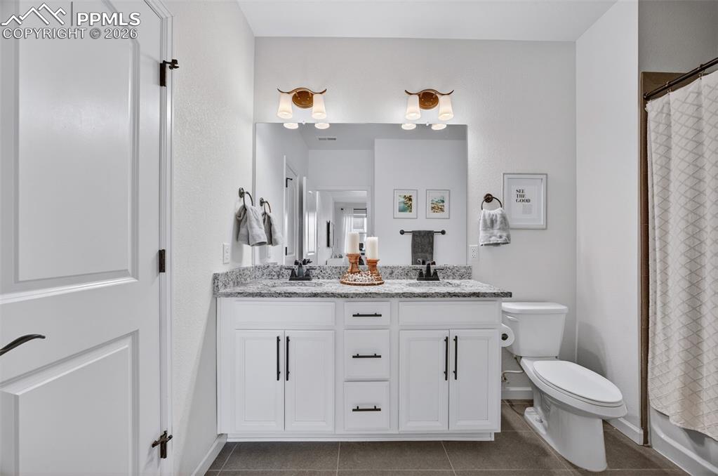 4658 Copeland Circle, Unit 103 Highlands Ranch, CO 80126 - Photo 27 of 37 a bathroom with a granite countertop toilet sink and mirror