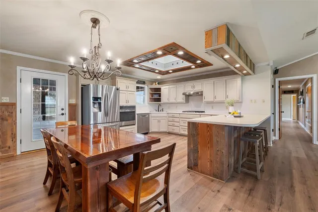a dining room with kitchen island a wooden floor and chairs
