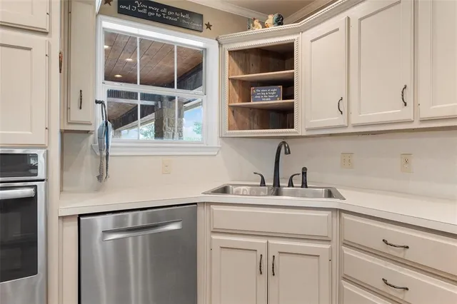 a kitchen with stainless steel appliances cabinets and a window