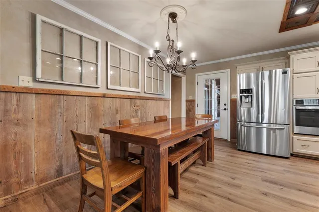 a dining room with furniture a chandelier and wooden floor