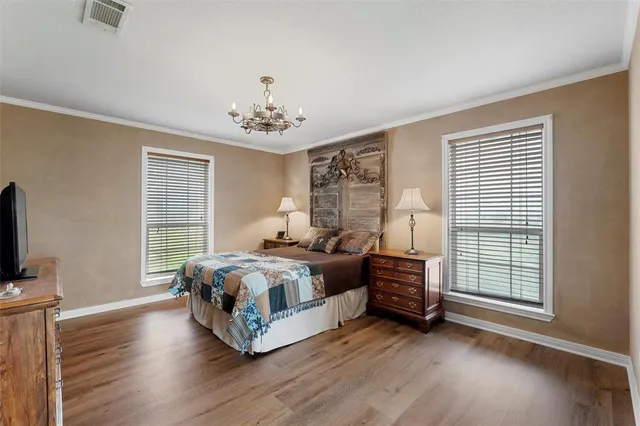 a spacious bedroom with a bed and a tv on table