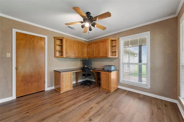 a kitchen with a refrigerator and wooden floors