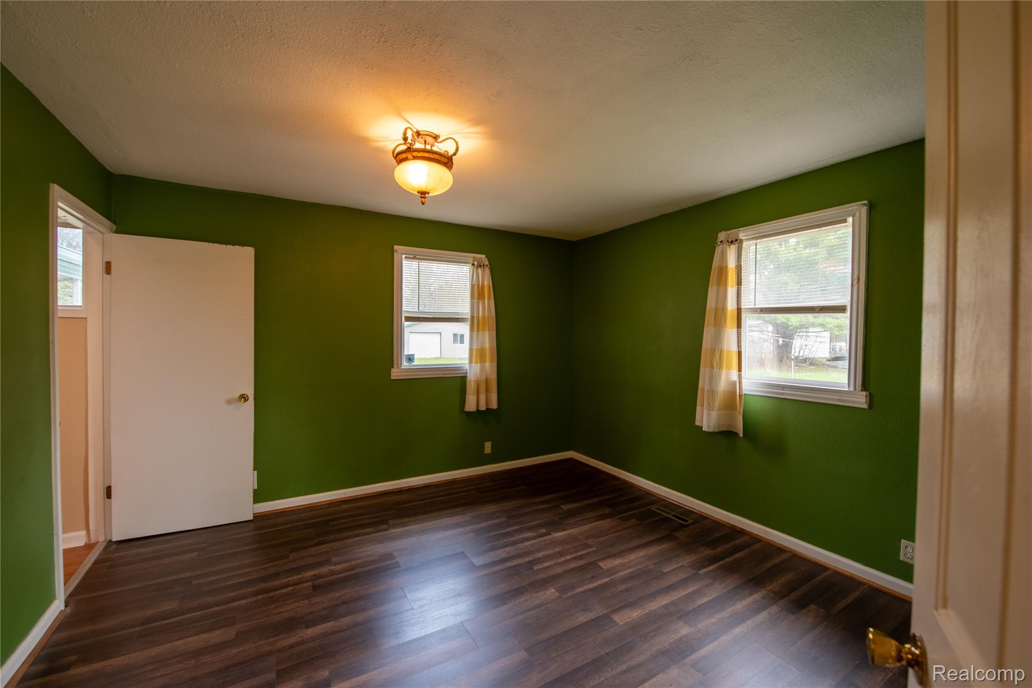 1190 Meadow Road Tawas City, MI 48763 - Photo 13 of 26 Empty room featuring dark wood finished floors and a textured ceiling