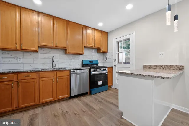 a kitchen with granite countertop wooden cabinets a sink and dishwasher