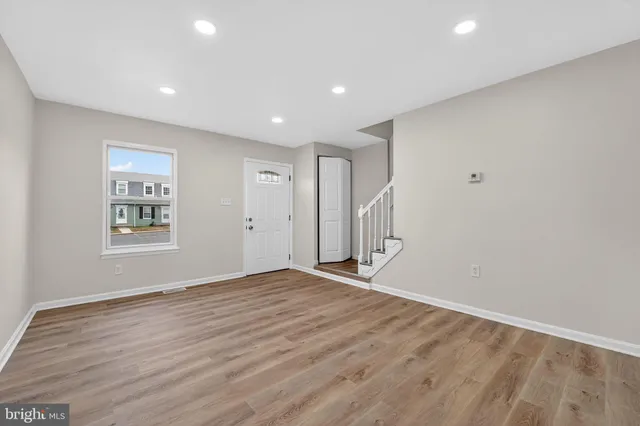 a view of an empty room with wooden floor