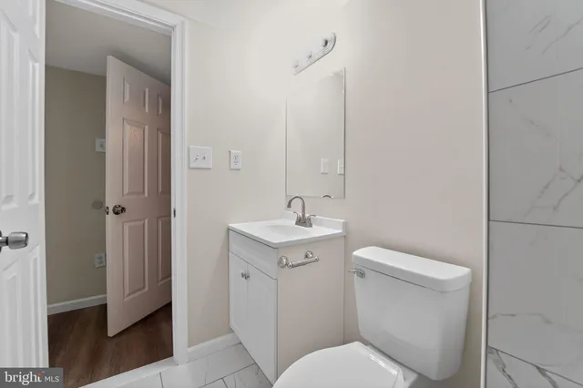a bathroom with a toilet a sink and mirror