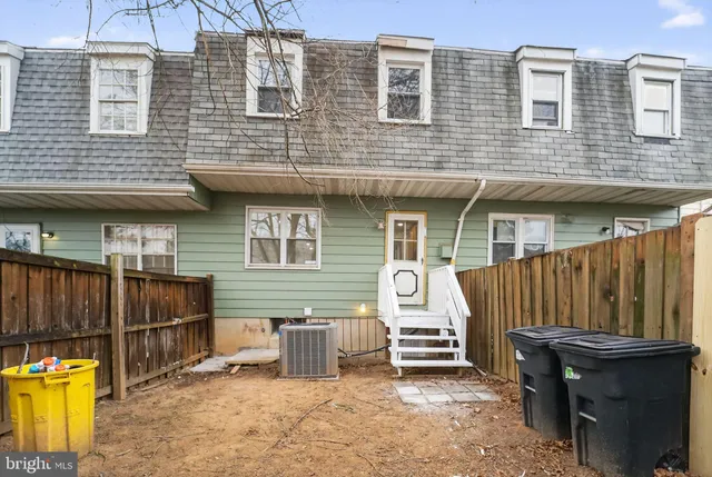a view of a house with a barbeque and wooden stairs
