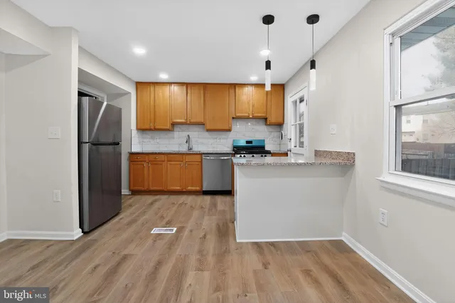 a kitchen with a refrigerator and a stove top oven