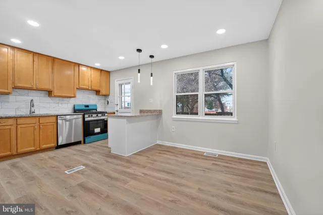 a kitchen with stainless steel appliances granite countertop a stove a sink and a microwave