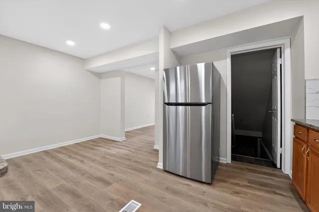 an empty room with wooden floor door and closet