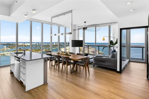 a living room with furniture a wooden floor and a large window