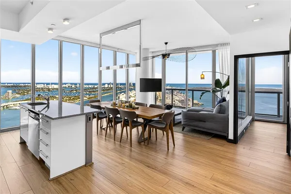 a living room with furniture a wooden floor and a large window