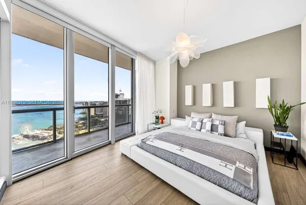 a spacious bedroom with a large bed and a chandelier