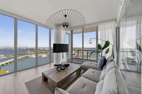 a living room with furniture and floor to ceiling window