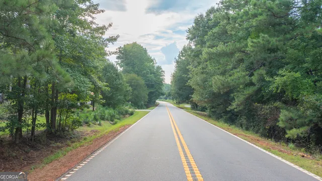 a view of a green field with trees in the background