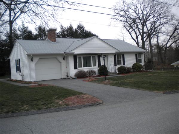 a front view of house with yard and trees around
