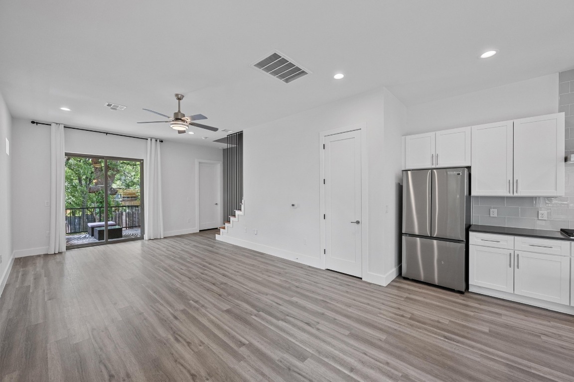 4705 Louis Avenue, Unit B Austin, TX 78721 - Photo 10 of 39 Kitchen featuring white cabinets, visible vents, freestanding refrigerator, light wood-style floors, and ceiling fan