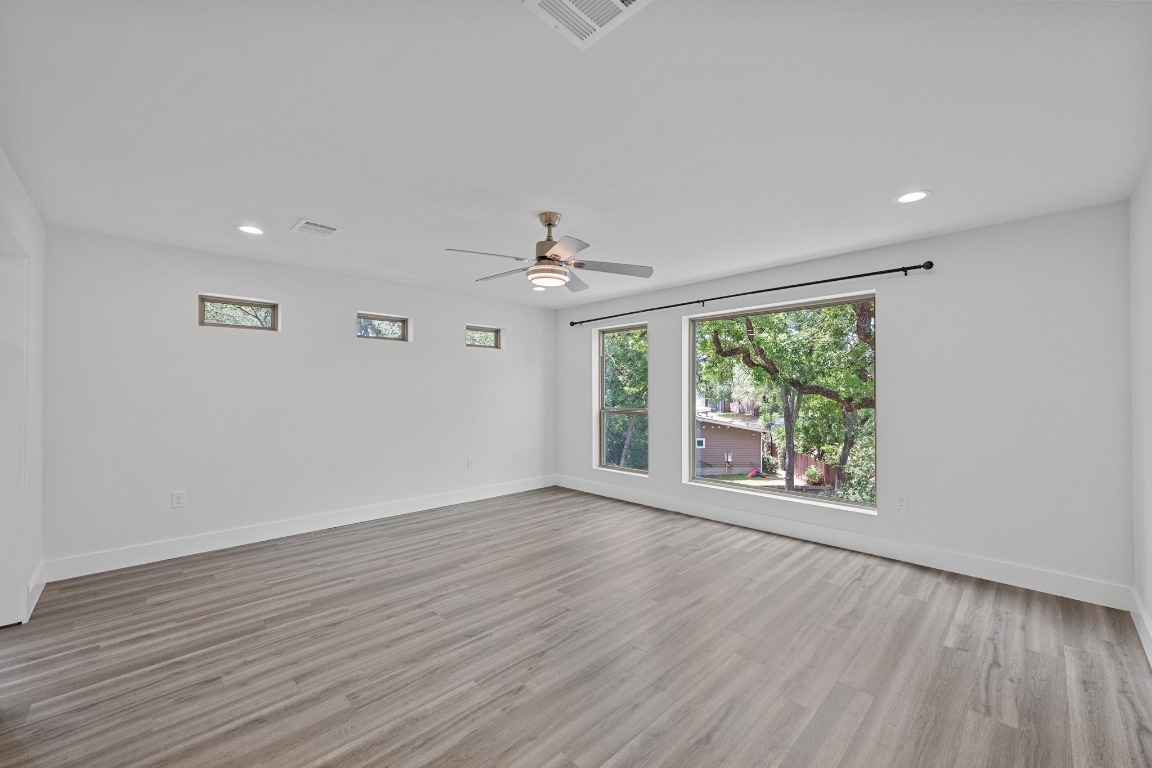 4705 Louis Avenue, Unit B Austin, TX 78721 - Photo 15 of 39 Unfurnished room featuring ceiling fan, baseboards, wood finished floors, and visible vents