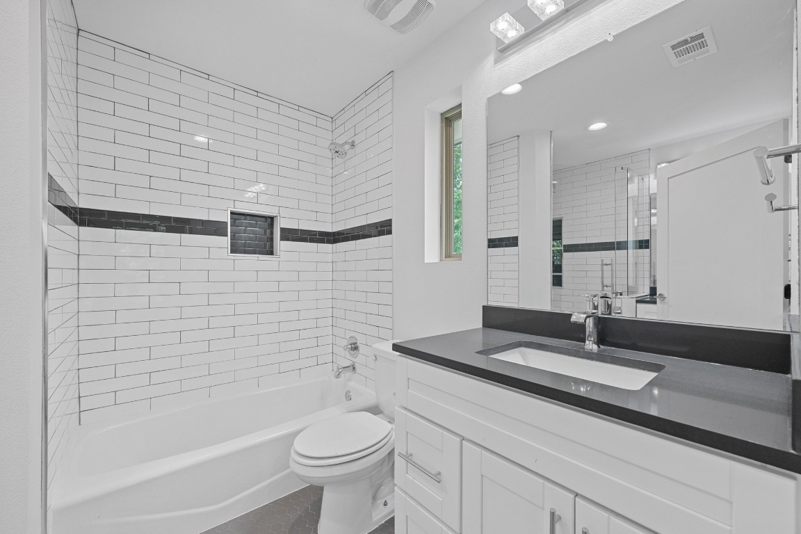 4705 Louis Avenue, Unit B Austin, TX 78721 - Photo 17 of 39 Bathroom with bathing tub / shower combination, visible vents, vanity, and toilet