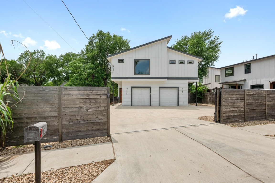4705 Louis Avenue, Unit B Austin, TX 78721 - Photo 2 of 39 View of side of home featuring an attached garage, concrete driveway, and fence