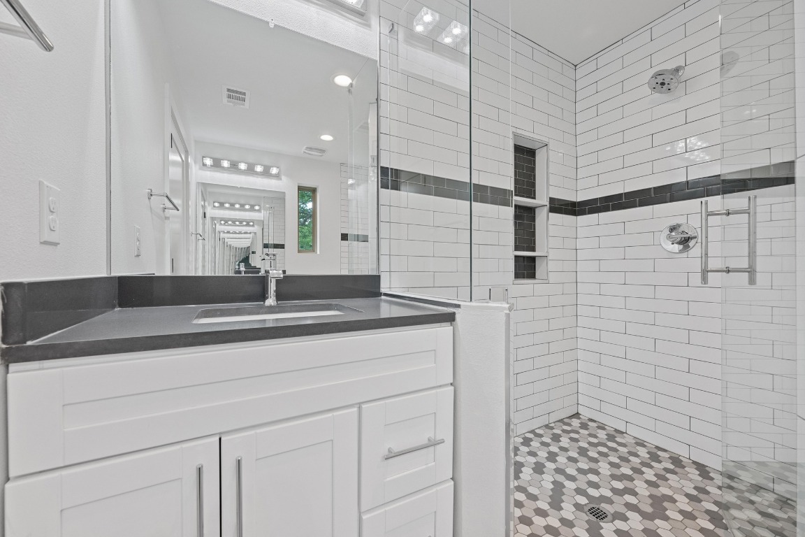 4705 Louis Avenue, Unit B Austin, TX 78721 - Photo 19 of 39 Full bathroom featuring vanity, visible vents, and tiled shower