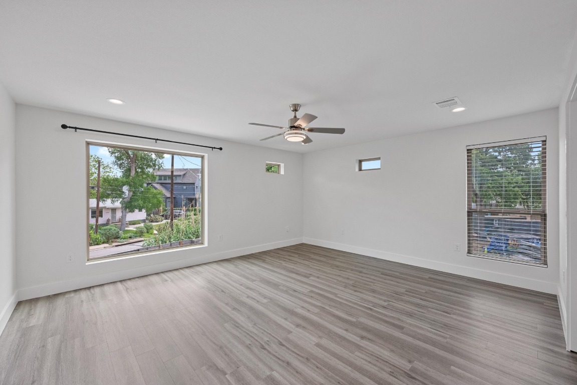 4705 Louis Avenue, Unit B Austin, TX 78721 - Photo 21 of 39 Empty room featuring visible vents, wood finished floors, baseboards, and ceiling fan