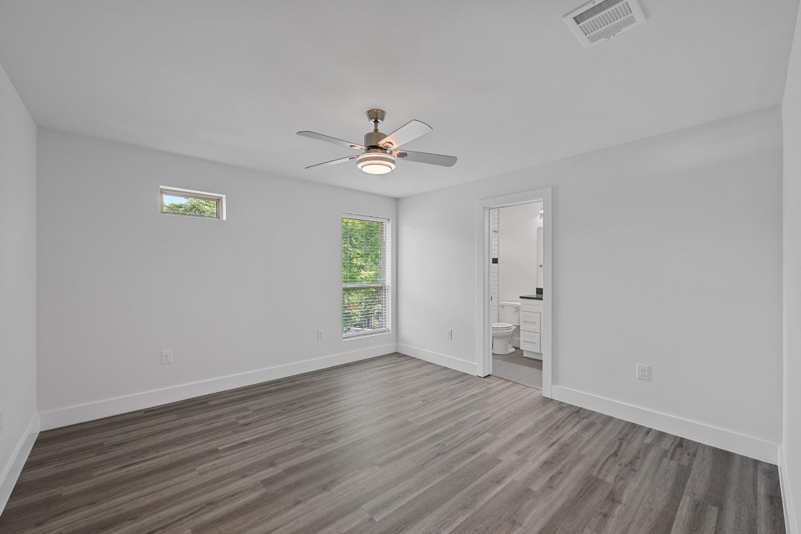 4705 Louis Avenue, Unit B Austin, TX 78721 - Photo 23 of 39 Unfurnished bedroom with visible vents, dark wood finished floors, and multiple windows