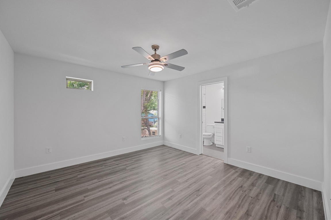 4705 Louis Avenue, Unit B Austin, TX 78721 - Photo 25 of 39 Unfurnished room with visible vents, baseboards, wood finished floors, and ceiling fan
