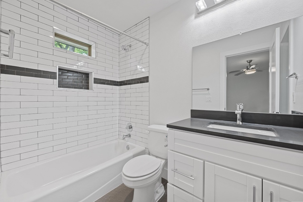 4705 Louis Avenue, Unit B Austin, TX 78721 - Photo 26 of 39 Bathroom featuring shower / bathing tub combination, toilet, vanity, and a ceiling fan
