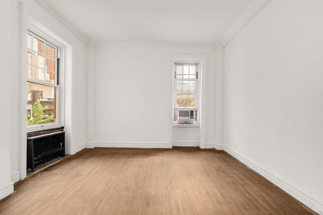 150 East 72nd Street, Unit 6S Manhattan, NY 10021 - Photo 13 of 23 an empty room with wooden floor and windows