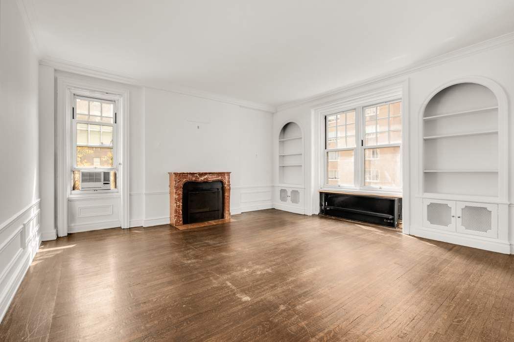 150 East 72nd Street, Unit 6S Manhattan, NY 10021 - Photo 2 of 23 an empty room with fireplace and windows