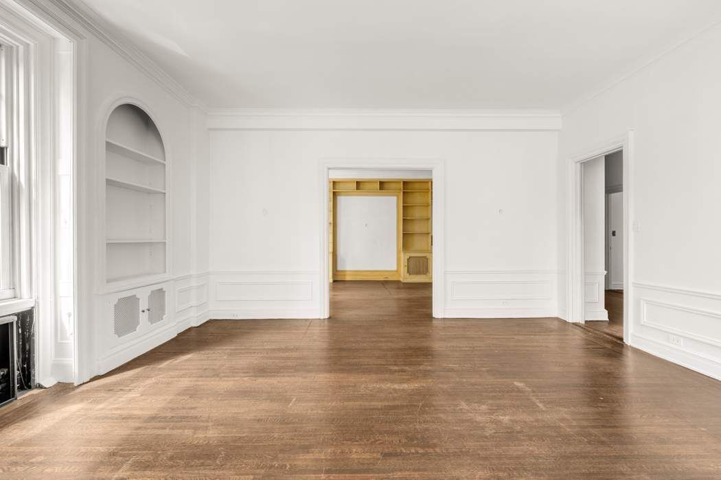 150 East 72nd Street, Unit 6S Manhattan, NY 10021 - Photo 4 of 23 an empty room with wooden floor and windows