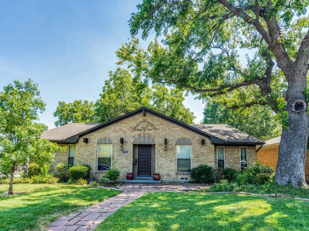 View of front of home featuring brick siding, a front yard, and a shingled roof