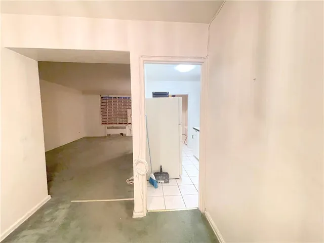 a view of a hallway with wooden floor and a bathroom