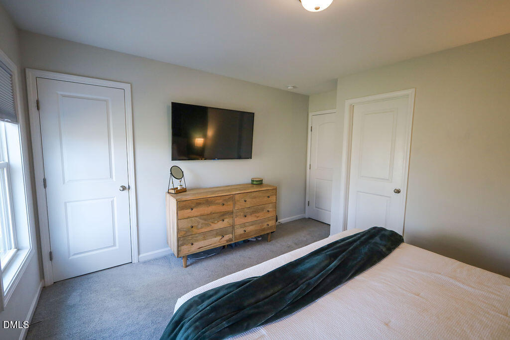 230 South Raleigh Street Angier, NC 27501 - Photo 27 of 38 a bedroom with a bed and a flat screen tv