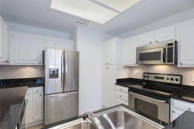 a kitchen with a refrigerator and a sink