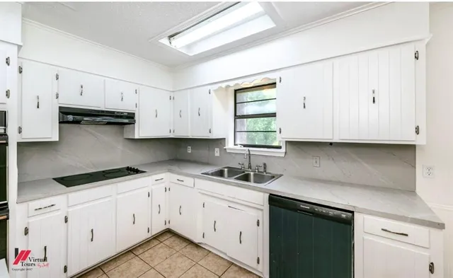 a kitchen with cabinets appliances a sink and a window