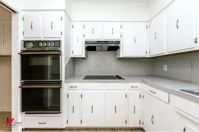 a kitchen with stainless steel appliances white cabinets and a stove