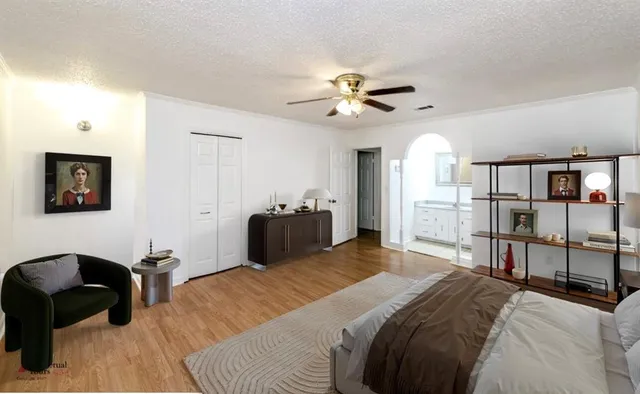 a bedroom with a bed a couch and a chandelier