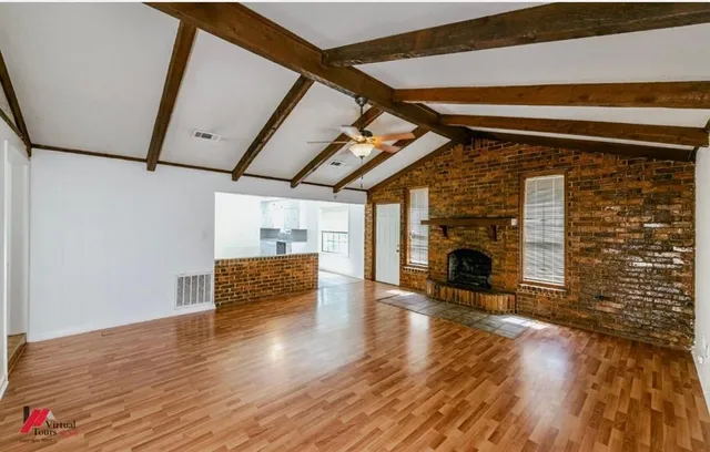 a view of livingroom with furniture wooden floor fire place and windows