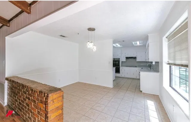 a view of kitchen with refrigerator and window