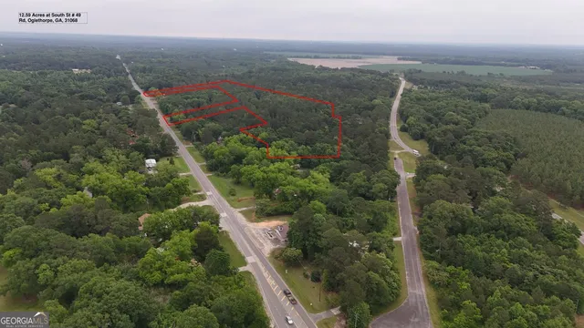 an aerial view of residential houses with outdoor space and trees