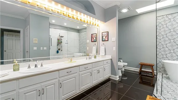 a spacious bathroom with a double vanity sink a mirror and a toilet