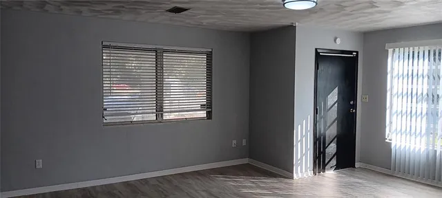 an empty room with wooden floor and a window