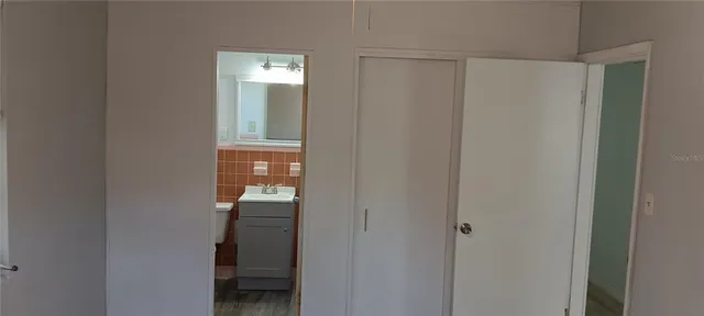 a view of a hallway with wooden floor and closet