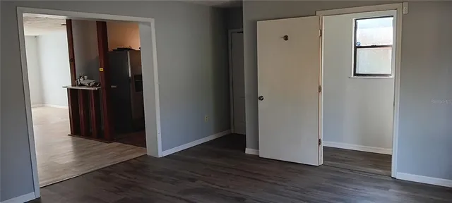 an empty room with wooden floor and closet