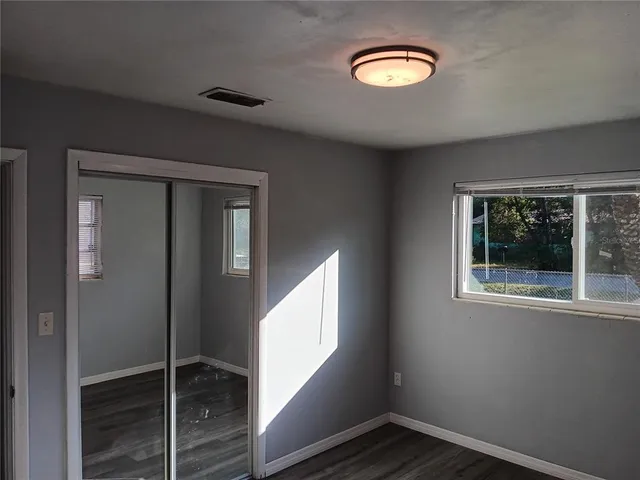 an empty room with a window and closet