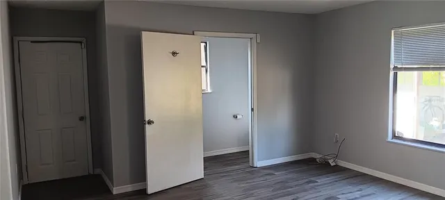 an empty room with wooden floor and a window